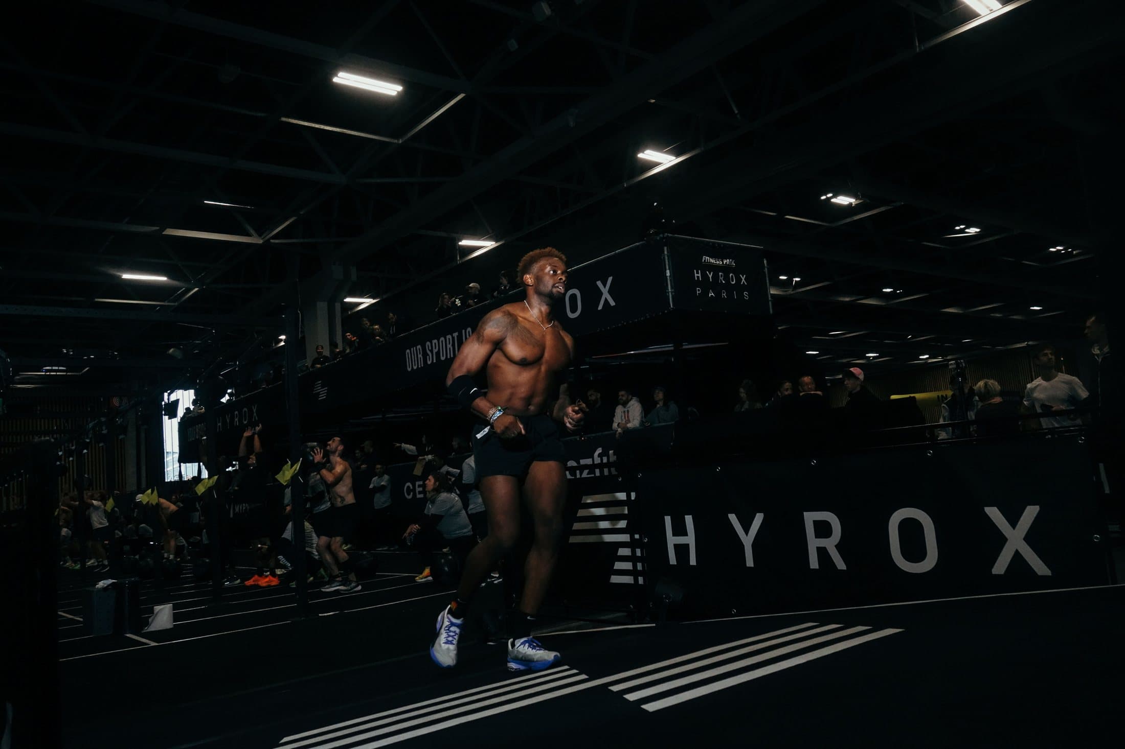 Le coach en course pendant un Hyrox à Paris, sous les projecteurs de la halle